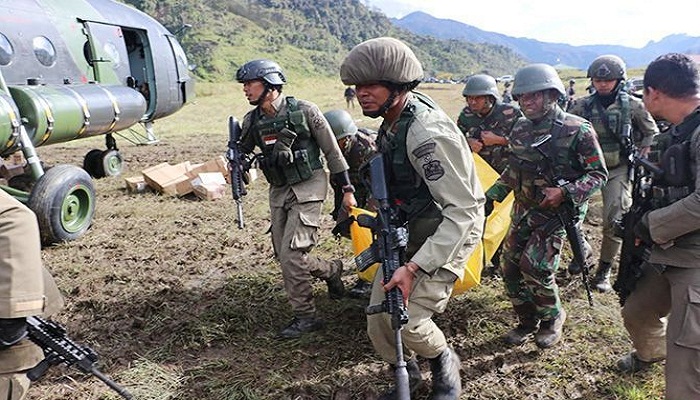 TNI sedang mengevakuasi jenazah korban kekejaman kelompok separatis. Foto; Jawa Pos
