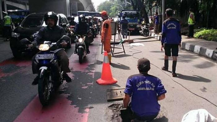 Pasukan oranye dan biru membersihkan gorong-gorong di kawasan Kuningan, Jakarta. Foto: Viva