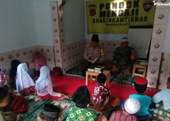 BRIGADIR Didi Dwi Purnomo tengah mengajarkan mengaji di Pondok Mengaji di Desa Priangan Jaya, Kecamatan Sukalarang, Sukabumi. Foto: Pikiran Rakyat