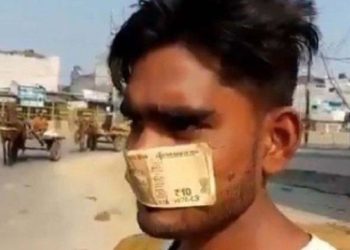 Ahmad, seorang pekerja di Meerut, India, terpaksa mengenakan uang pecahan 10 rupee sebagai masker karena tak punya cukup uang untuk membelinya. Foto: Gulf