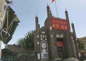 Masjid Jama, salah satu masjid di Cina dihiasi dengan bendera Tiongkok dan spanduk propaganda bertuliskan 'Cintai Partai, Cintai Negara' di daerah Kargilik di prefektur Kashgar. Foto: RFA.ORG
