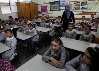 Siswa duduk di kelas mereka pada hari pertama tahun ajaran baru di Sekolah Dasar yang dikelola UNRWA di kamp pengungsi Shati di Kota Gaza, Sabtu (8/8/2020). Foto: AP