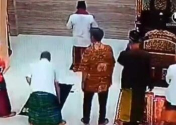 Pelaku berbaju batik cokelat berdiri di saf depan dan sempat mengikuti salat berjemaah sebelum memukul imam masjid (Foto: Tangkapan layar video)